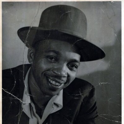 A vintage black-and-white photo of a smiling man, likely a veteran, wearing a wide-brimmed hat and suit jacket. The image, marked by visible scratches and signs of aging, could be from the Memphis Area Branch of ASALH’s monthly meeting. A vintage black-and-white photo of a smiling man, likely a veteran, wearing a wide-brimmed hat and suit jacket. The image, marked by visible scratches and signs of aging, could be from the Memphis Area Branch of ASALH’s monthly meeting.